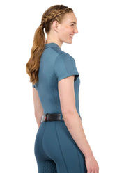 Woman wearing a muted blue short sleeve polo shirt, side view