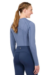 Woman wearing a blue long sleeve riding top, rear view