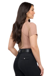 Woman wearing a tan short sleeve quarter zip riding top, rear view
