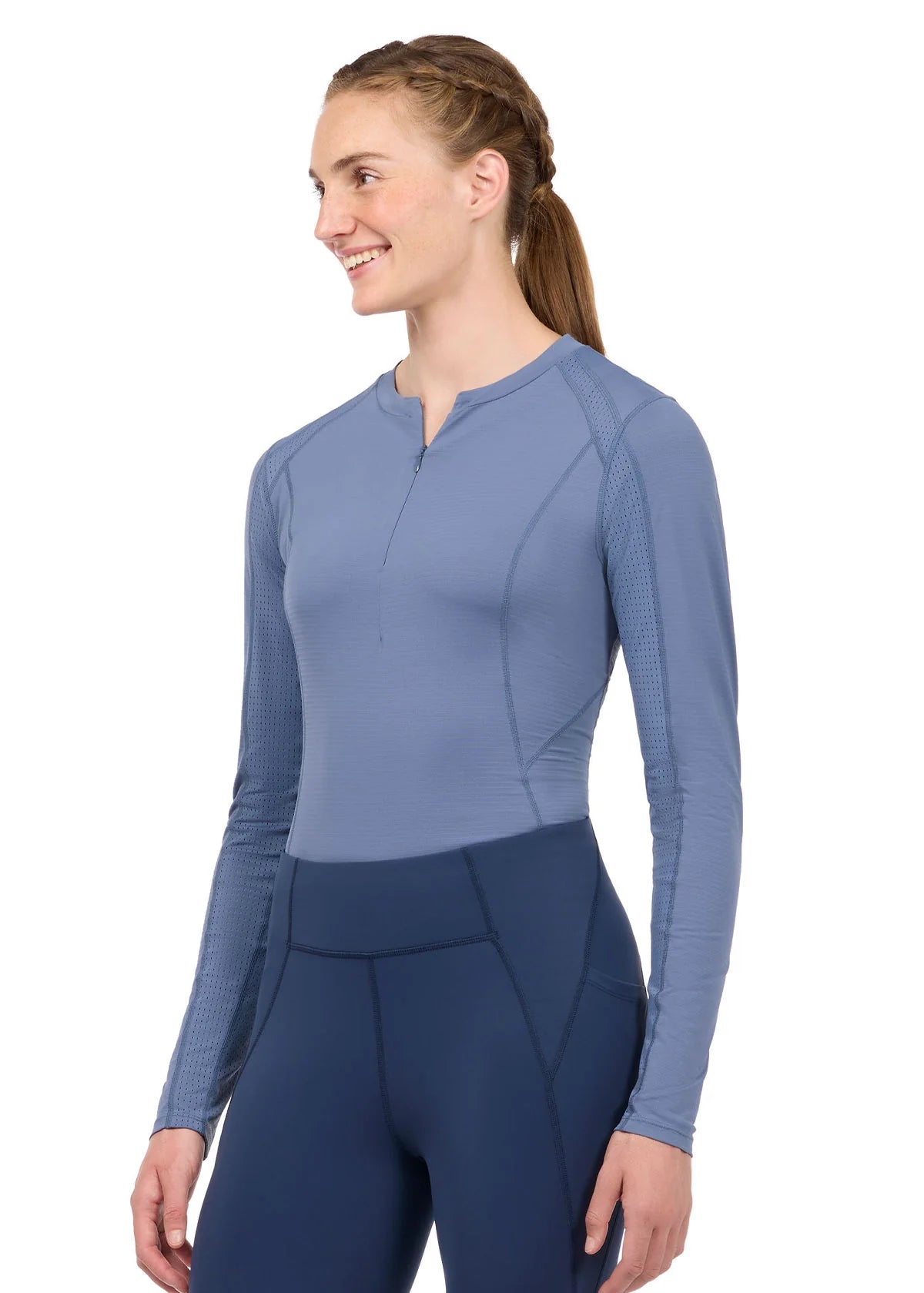 Woman wearing a blue long sleeve riding top, front view