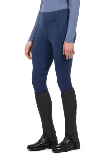 Woman wearing blue riding tights with tall boots, side view