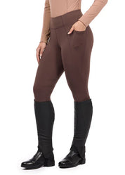 Woman wearing brown riding tights with tall boots, front view