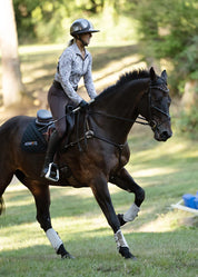Rider wearing an equestrian print riding shirt riding a horse in motion