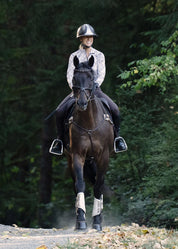 Rider wearing an equestrian print riding shirt riding a horse