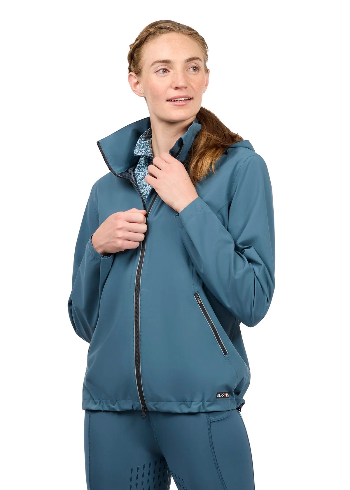 Woman wearing a teal waterproof jacket, front view