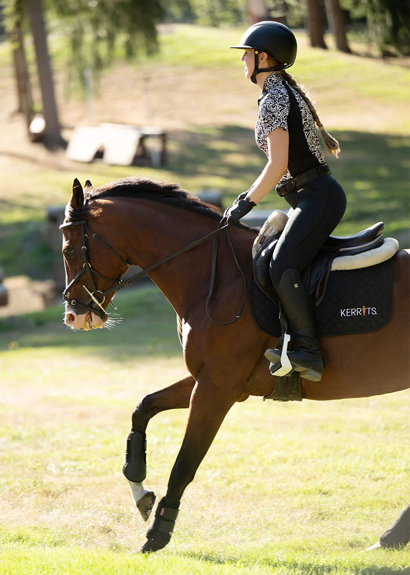Rider wearing a patterned shirt riding a horse