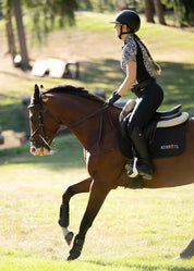 Rider wearing a patterned shirt riding a horse