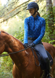Rider wearing gray riding tights riding a horse