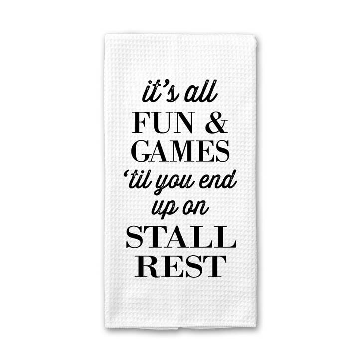 Front view of a folded Stall Rest Canary Road Kitchen Towel on a white background