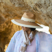 Angled front view of a woman wearing the Dorfman Milano Elgans Hat while standing in a cave