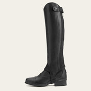 Side view of the Ariat Close Contour Half Chaps over a paddock boot on a plain background