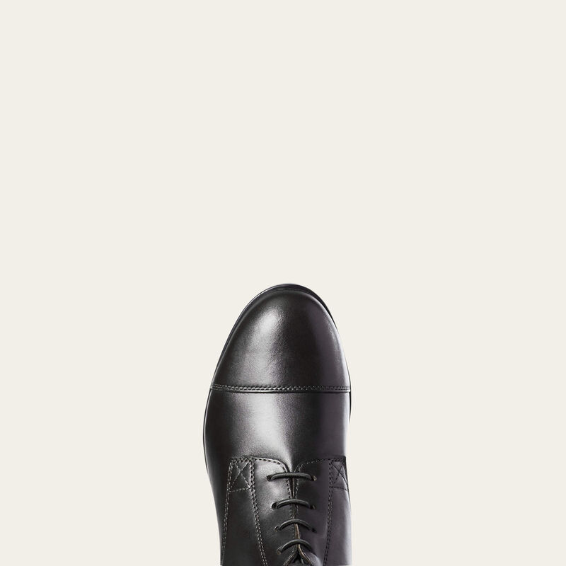 Close-up view of the toe cap of the black Ariat Heritage Contour II Field Zip Tall Riding Boot on a gray background