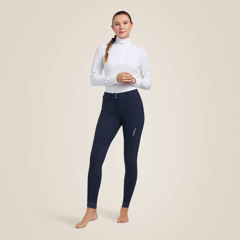 Full body front view of a female model wearing the navy Ariat Tri Factor Grip Knee Patch Breech on a plain background