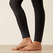 Close-up view of the lower leg of the black Ariat Tri Factor Grip Knee Patch Breech in a studio setting