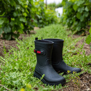 View of a pair of Navy Ariat Kelmarsh Mid Rubber Boots on the grass outside