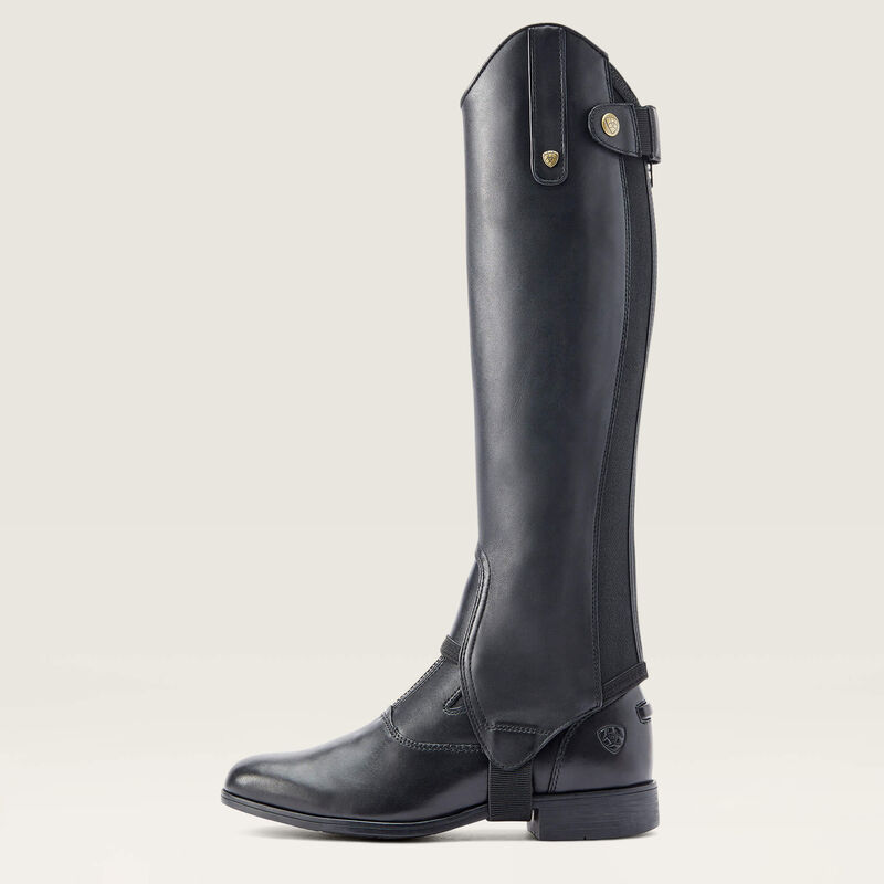 Side view of the black Ariat Heritage Contour Half Chap over a paddock boot
