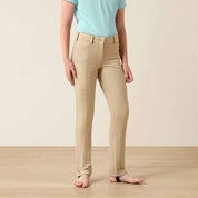 Front view of a young girl wearing the Ariat Youth Protege Jod Knee Patch Breeches in tan in a studio setting