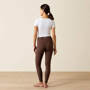 Full body back view of a model wearing the brownAriat Tri Factor NT Full Seat Breech and a white shirt in a studio setting