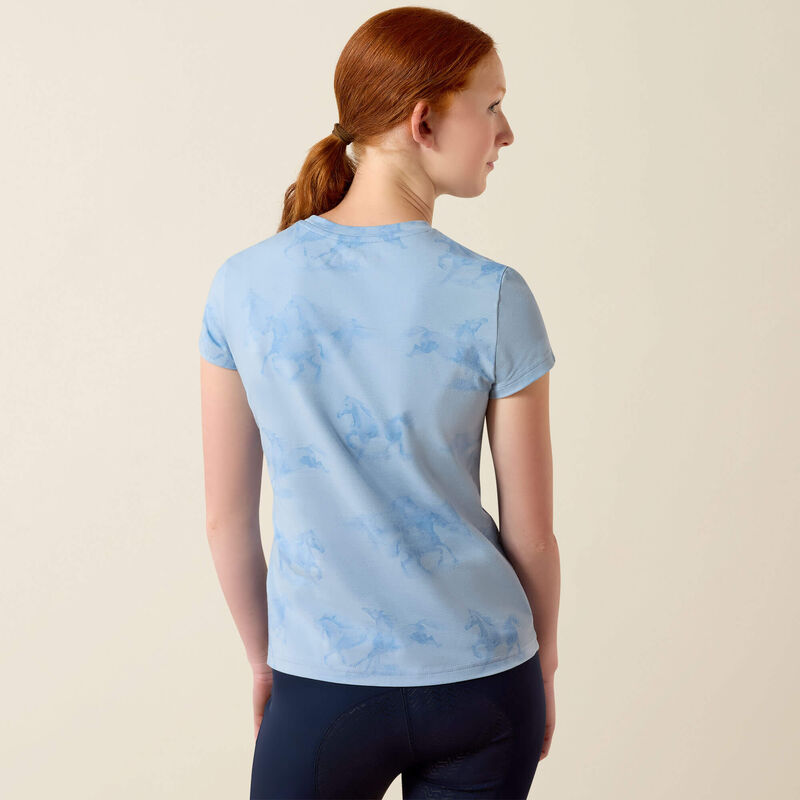 Back view of young girl wearing the Ariat Youth Mirage T-Shirt in blue in a studio setting