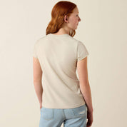 Back view of a young girl wearing the Ariat Youth Floral Leap T-Shirt in tan in a studio setting