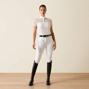 Front view of model wearing the Ariat Allure Short Sleeve Show Shirt in white, white breeches, and tall black boots in a studio setting