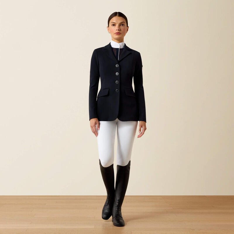 Full body front view of a female model wearing the Navy Eclipse Ariat Allure Show Coat with white breeches on a plain background