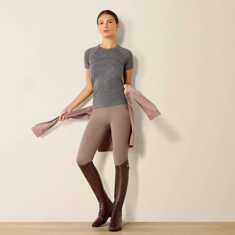 Full front view of a model wearing the Ariat Sustain Short Sleeve Baselayer in gray with brown breeches and tall brown boots in a studio