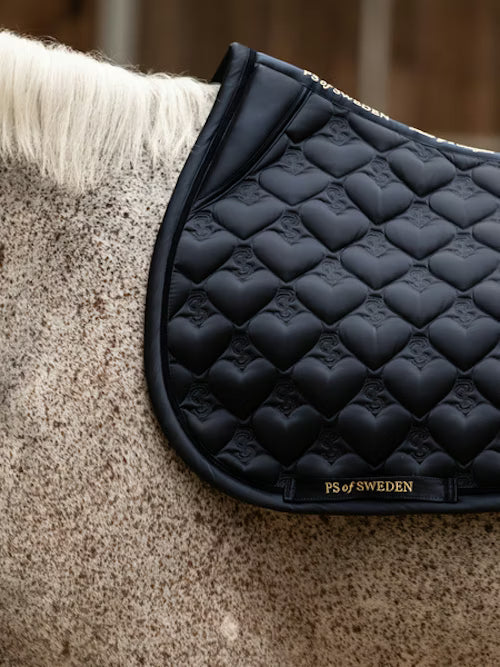 Side view of a gray horse wearing the navy PS of Sweden Heart Jump Pad
