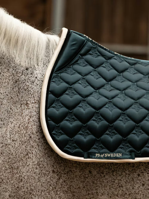Side view of a gray horse wearing the green PS of Sweden Heart Jump Pad
