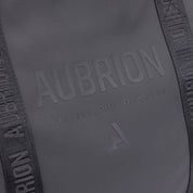 Close-up view of the tone-on-tone name Aubrion and "Live Explire Discover" on the front of the Aubrion React Tote Bag