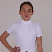 Front view of a young female model wearing the white Aubrion Young Rider Optima GX Show Shirt on a plain background
