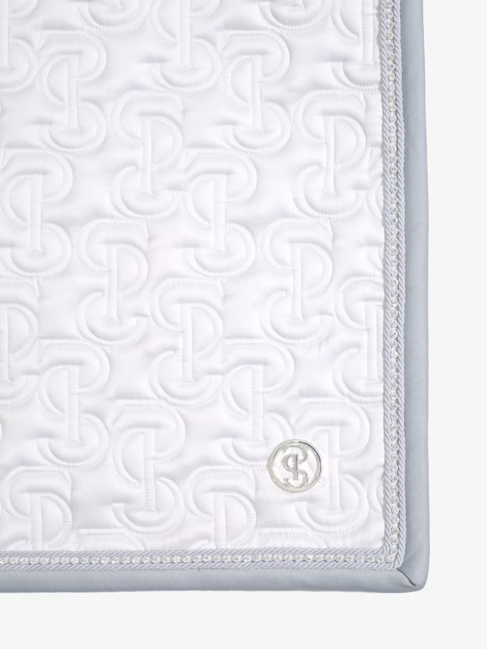 Close-up view of the back corner of the white PS of Sweden Crystal Satin Dressage Saddle Pad on a white background