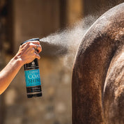Side view of someone spraying a horse with the Carr & Day & Martin Canter Coat Shine Conditioner