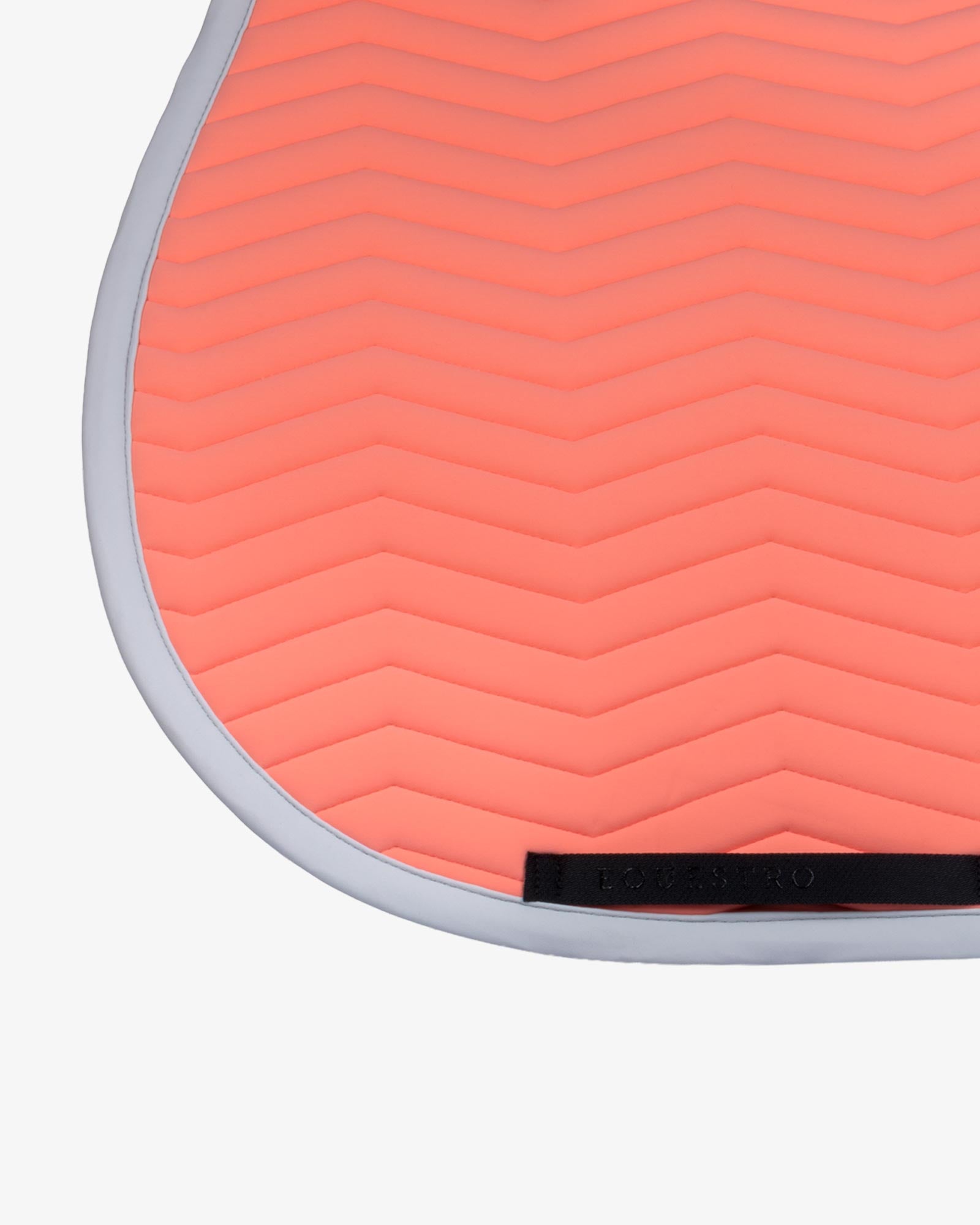 Close up view of the black girth keeper on the Equestro Wave Quilting Jumping Saddle Pad In Technical Fabric in a coral color on a white background