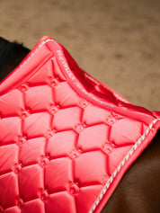 Top view of the spine of the Pink Guava PS of Sweden The Original Monogram Jump Saddle Pad worn by a horse