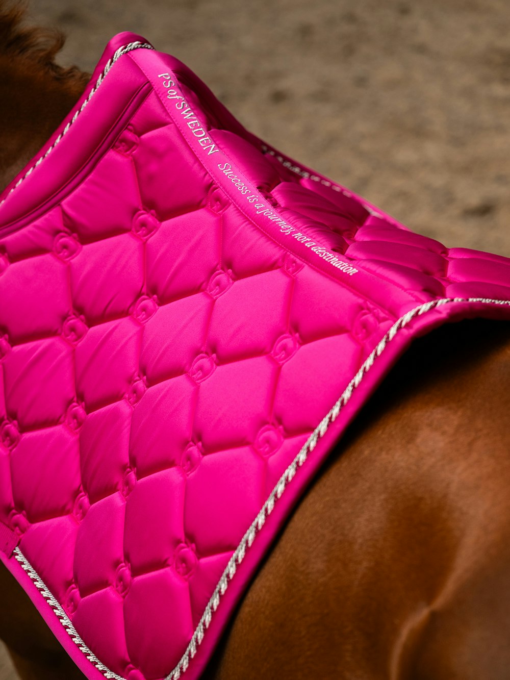 Top view of the spine of the Hot Hibiscus PS of Sweden The Original Monogram Jump Saddle Pad worn by a horse