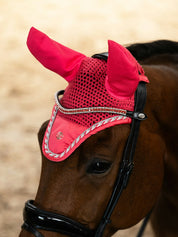 Angled front view of a bay horse wearing the pink guava PS of Sweden The Original Monogram Ear Bonnet