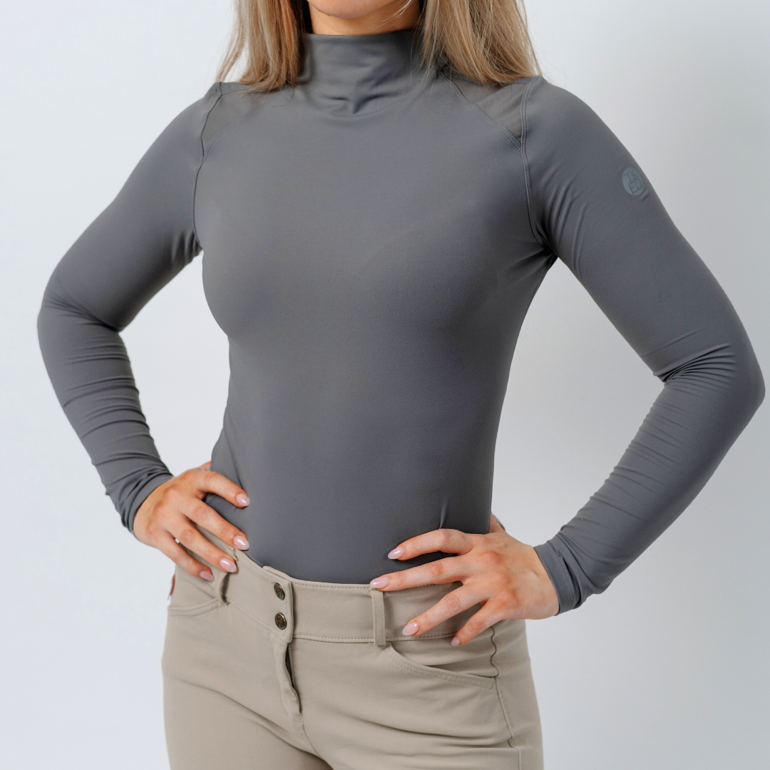 Front view of a female model wearing the Slate TKEQ Chloe High Collar Technical Top on a plain background