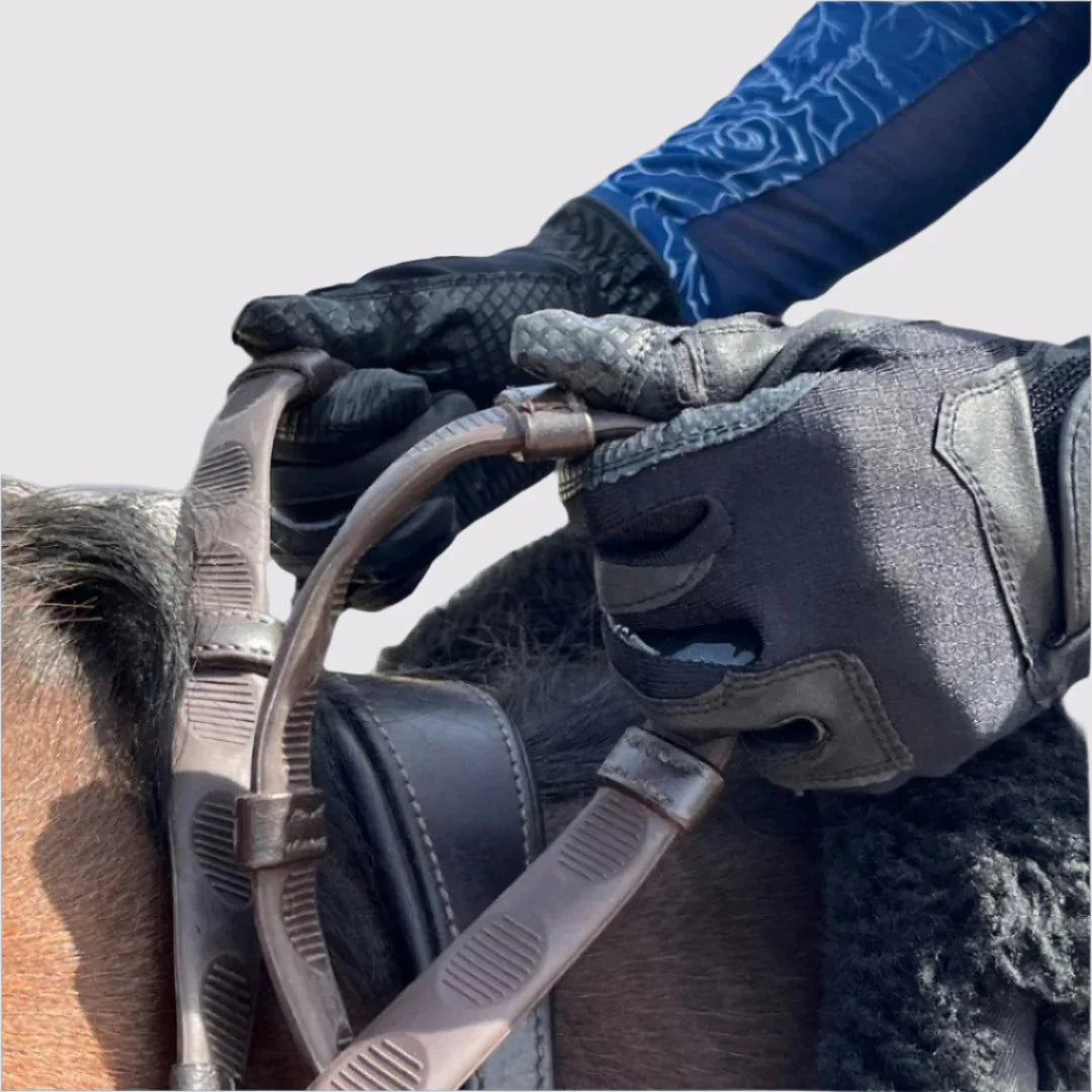 Close-up of a person riding a horse with a pair of brown Correct Connect Thumb Grip Reins in their hands