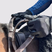 Close-up of a person riding a horse with a pair of brown Correct Connect Thumb Grip Reins in their hands