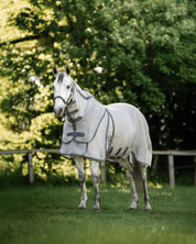 Horse wearing Horseware Rambo Optimo Protector Plus fly sheet in Silver/Thunderstorm Grey & Silver standing in a grassy paddock