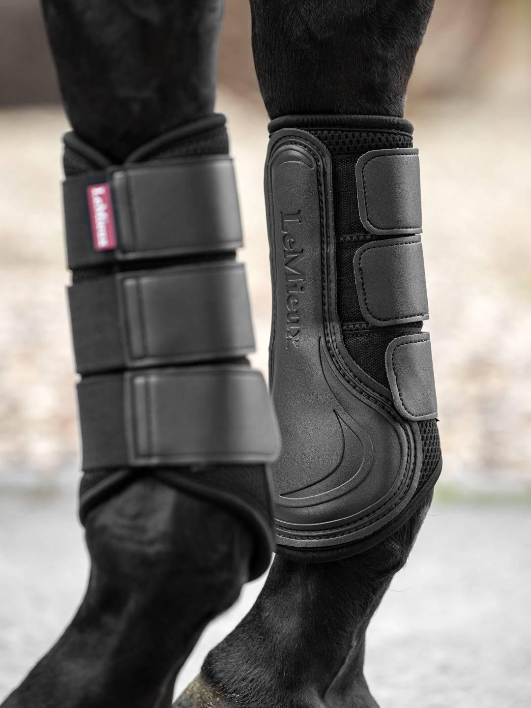 Horse wearing black LeMieux Mesh Brushing Boots standing on pavement