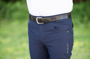 Close-up front view of a male model wearing the navy KL Select Men's Evan Full Seat Breeches while standing outside