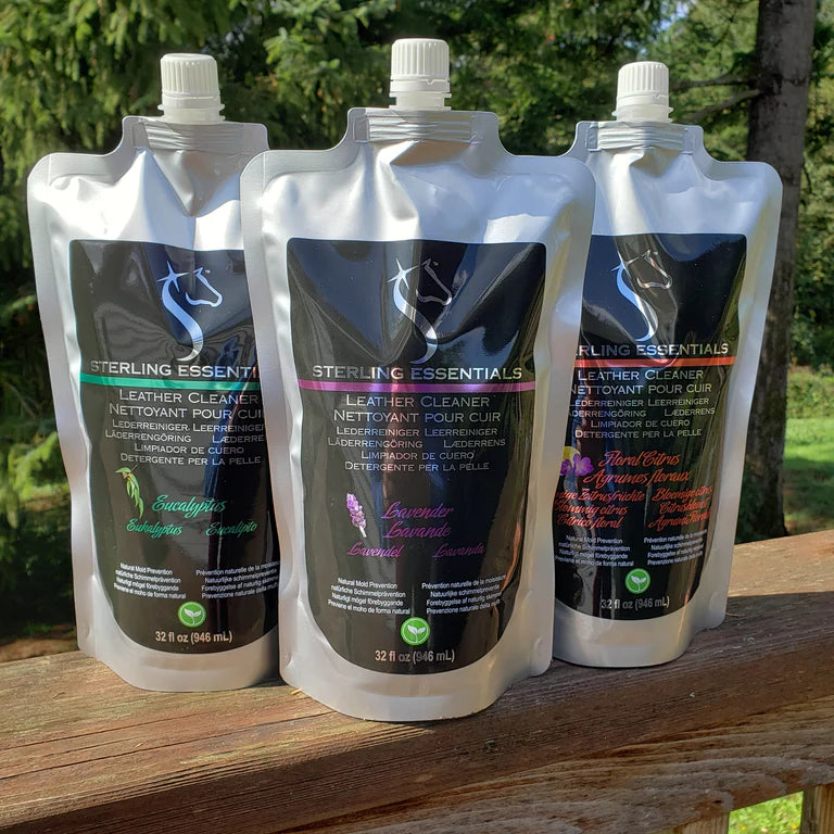 Front view of the 3 different scents of the 32oz Sterling Essentials Leather Cleaner on a wooden railing