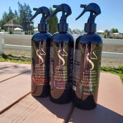 Front view of 3 16oz bottles, each with a different scent, of Sterling Essentials Leather Cleaner with an outdoor arena in the background