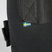 Close-up view of the Sweden flag tag on a black Back On Track Royal Quick Wrap