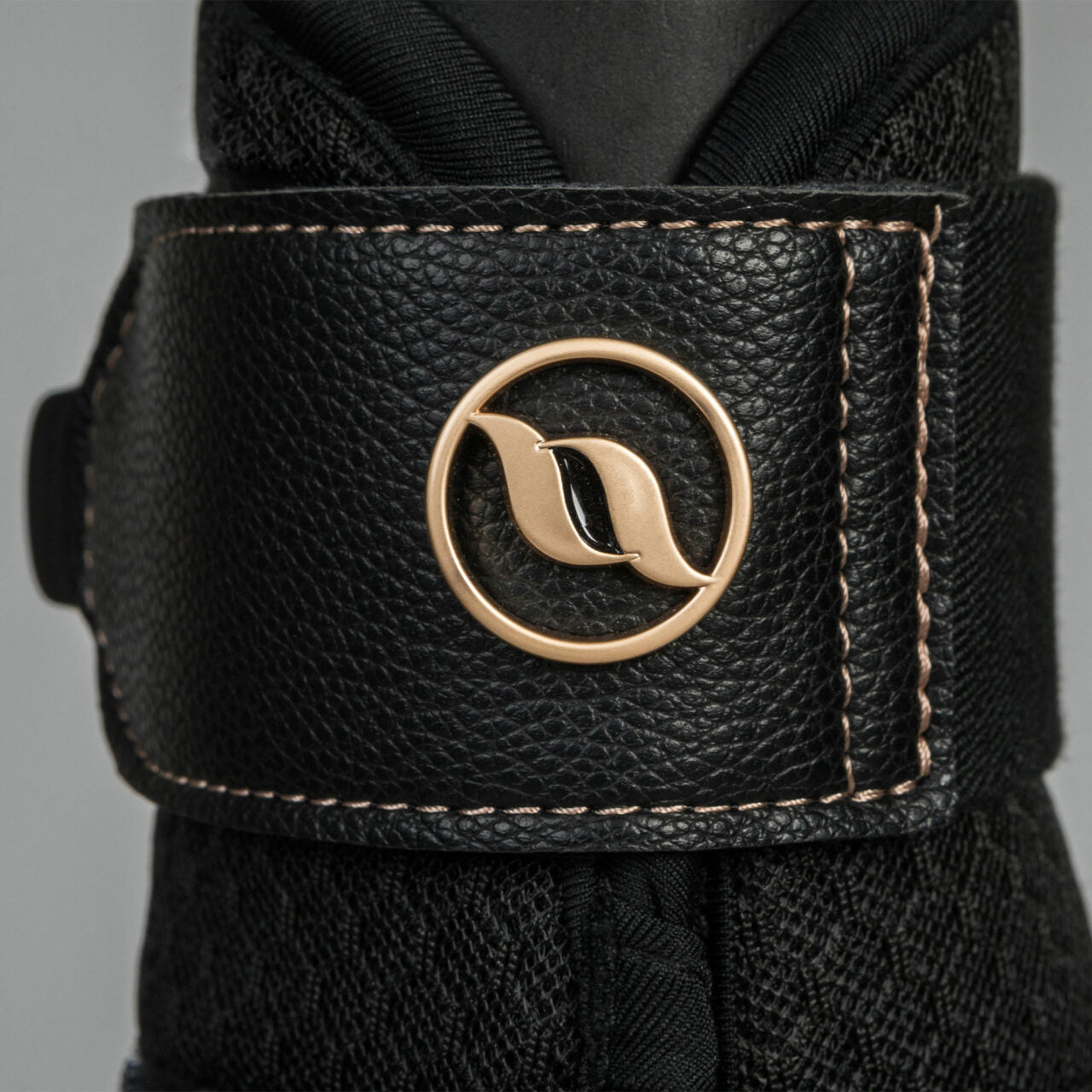 Close-up view of the velcro strap and Back on Track logo on a black Back on Track Deep Nights Brush Boot