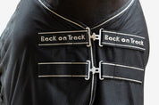 Close-up front view of the double buckles on the front of the black Back On Track Sienna Mesh Cooler Rug