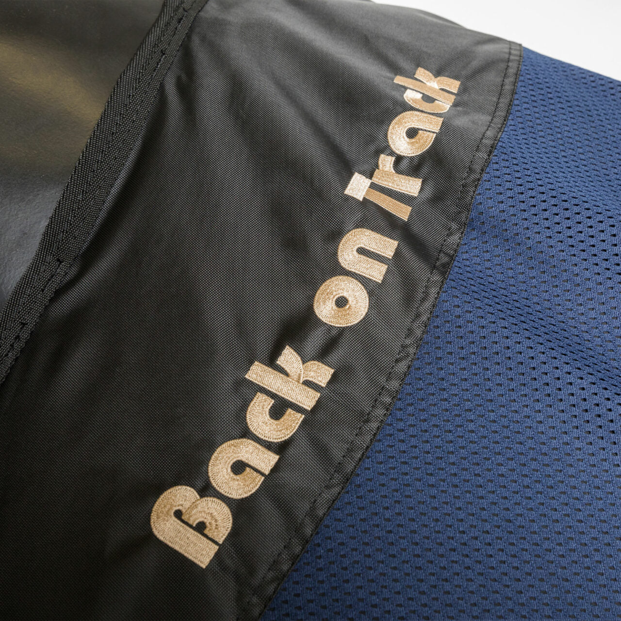 Close-up view of the Back on Track logo on the navy Back On Track Royal Mesh Sheet Deluxe