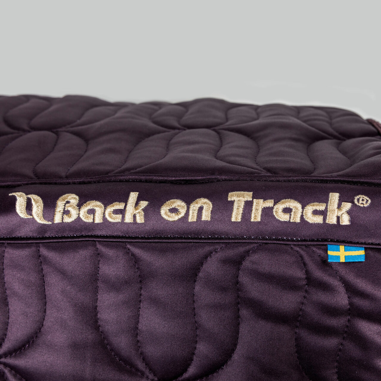 Close-up view of the spine on the plum Back on Track Deep Nights All-Purpose Saddle Pad